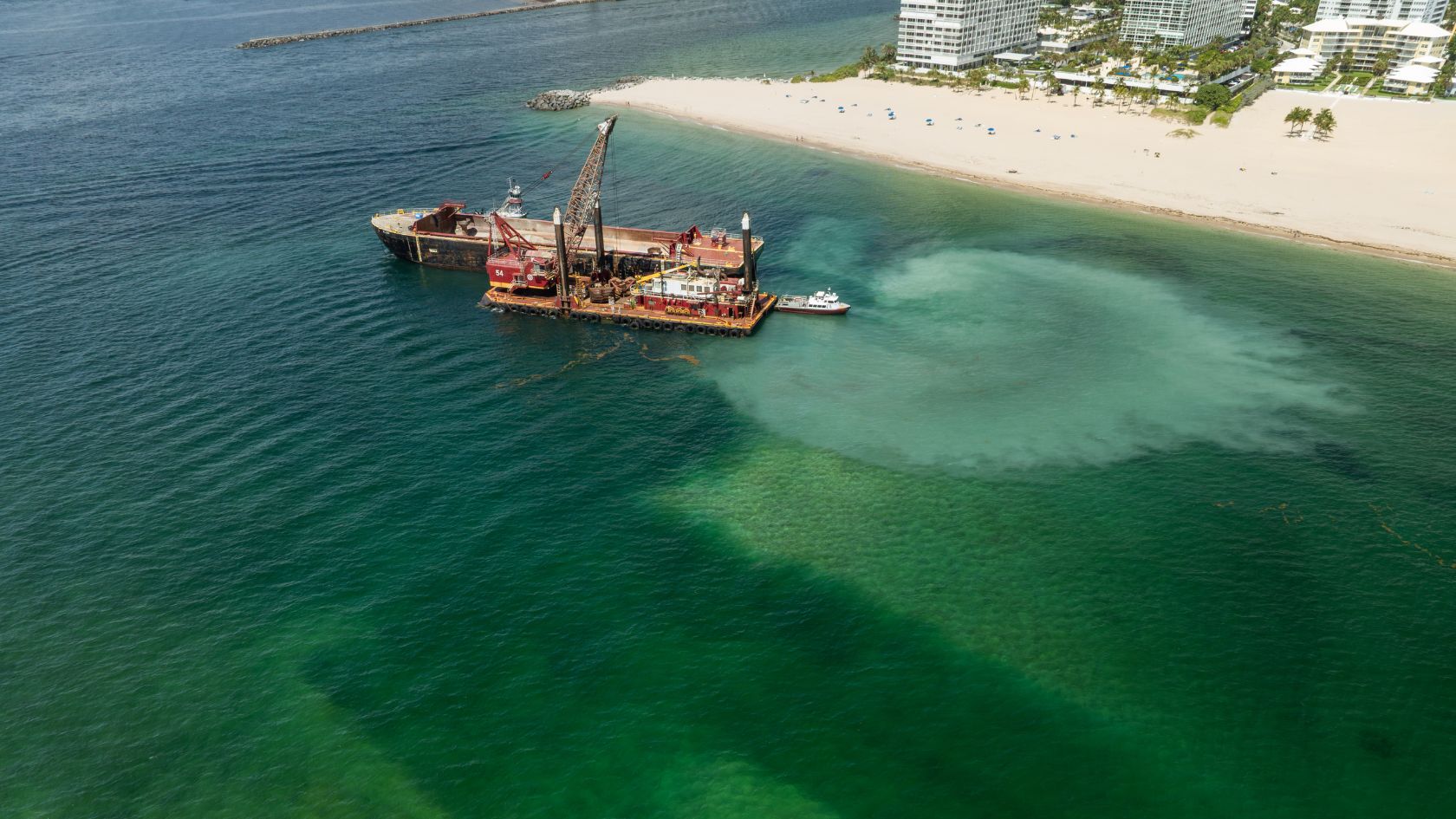 sand bypass dredge barge 54 plume near beach aerial